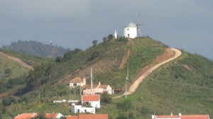 A windmill home sits on one of the many rolling hills.